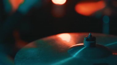 Arka planda renkli sahne ışıkları olan bir bagetle vurulduktan sonra zilin titremesi.