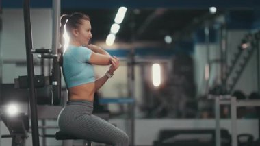 Sağlıklı bir kadın dinleniyor, kollarını açıyor ve düz bir karın için karın vakumu egzersizi yapıyor.