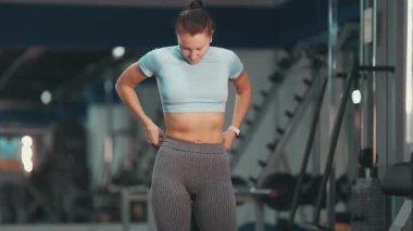 Başarılı bir antrenmandan sonra formda vücudunu ve kaslarını gururla sergileyen bayan sporcu