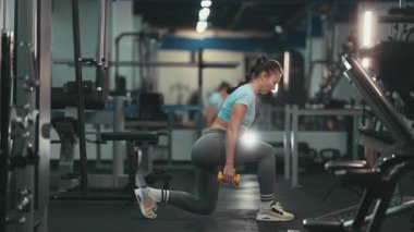 Spor giyim sektöründe güçlü bir kadın spor yaparken halterle saldırıyor.