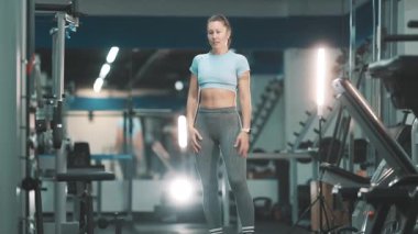 Formda atletik bir kadın modern bir fitness merkezinde akrobatik bir ters takla başarıyla indiriyor.