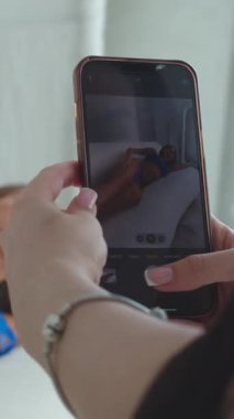 Mavi iç çamaşırlı seksi, zayıf bir kadın telefonda fotoğraf çekimi yapıyor. Orta çekim