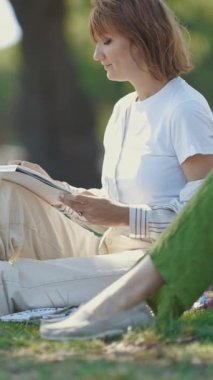 Parkta çizim yapan iki gülümseyen kadın. Orta çekim