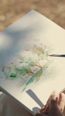 Doğada suluboya olan bir manzara çizmek. Kağıdın üzerine su damlaları düşürmek. Orta çekim