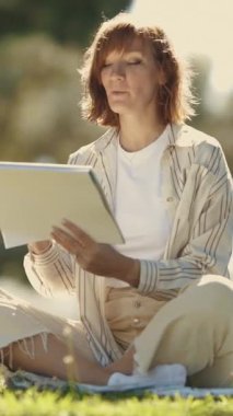 Suluboya resim yapan ve parkta konuşan yetişkin bir kadın. Orta çekim