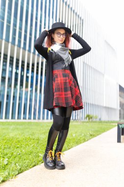 Açık havada poz veren genç kadın, moda, bireysellik ve kentsel yaşam tarzını ifade ediyor.