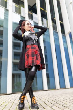 Açık havada poz veren genç bir kadın, şehir modasını ve bireyselliği ifade ediyor.