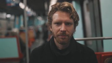 Sevimli bir genç adam farklı duygular ifade ediyor toplu taşıma treninde yolculuk ederken.