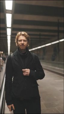 Kızıl saçlı yakışıklı genç adam modern bir yeraltı istasyonunda nakledilmeyi bekliyor.