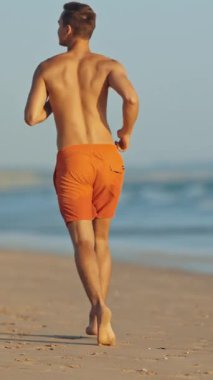 Yaz mevsiminde sahilde koşan cankurtaran.