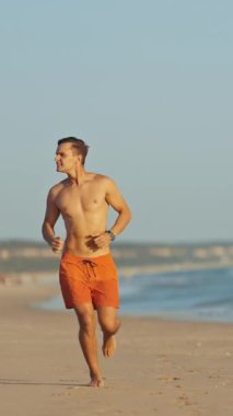 Yaz mevsiminde sahilde koşan cankurtaran.