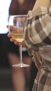 Etkinlikte elinde şarap kadehleri olan ve konuşan iki başarılı kadın. Orta çekim