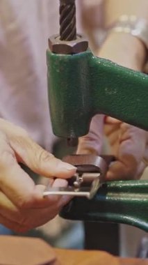 Bir kadın kemeri bir makineyle kemere bağlıyor. Orta çekim