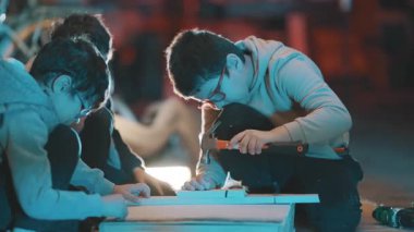 Marangozluk projesinde birlikte çalışan genç öğrenciler pratik beceriler öğreniyorlar.