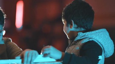 İnşaat becerilerini öğrenirken tahta tahtaya çivi çakan mutlu genç çocuk.