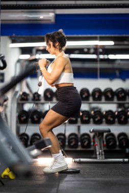 Kablolu yayın yapan kadın, kalça ve bacak kasları egzersizlerine odaklanıyor.