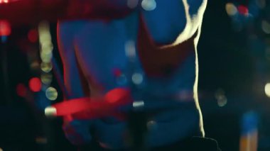Bir gece kulübünün partisinde mavi ve kırmızı ışıkların altında tutkulu bir şekilde dans eden tanınmayan üstsüz bir adam.