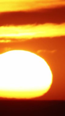 Okyanusun üzerinde büyük ve parlak batan güneş. Orta çekim