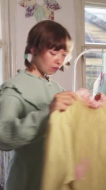 Bir kadın tasarımcı bir sonraki işlem için askısı olan bir elbise seçer. Orta çekim