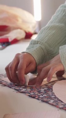 Kadın tasarımcı çiçek desenli kumaşta kağıt desenler kullanarak iz bırakıyor. Orta çekim