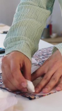 Kadın tasarımcı çiçek kumaşında sabun izleri yapıyor. Kağıt desenler kullanarak. Orta çekim