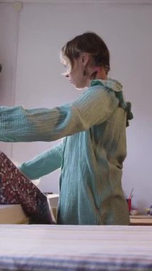 Bir terzi atölyede çiçek dokusunu düzleştirir. Orta çekim