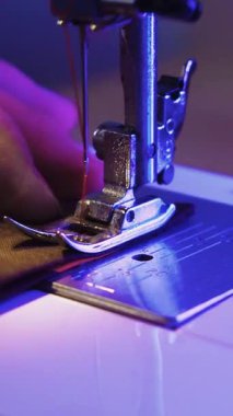 Dikiş makinesine kumaş parçaları dikiyorum. Kapat.