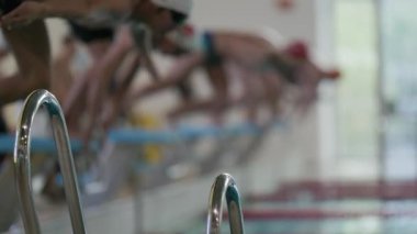 Profesyonel yüzücüler yarışma sırasında aynı anda başlangıç bloklarından suya atlıyorlar.