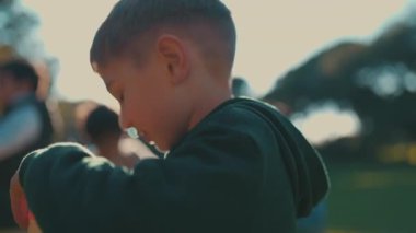 Güneşli bir günde parkta sabun köpüğüyle oynayan bir grup mutlu çoklu etnik çocuk.