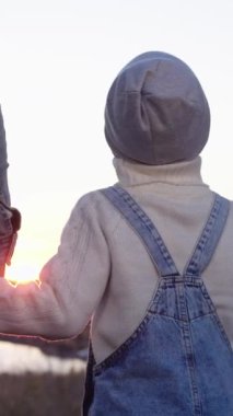 Bir adam ve bir kadın küçük bir çocukla el ele tutuşuyorlar.