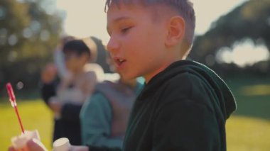 Çocuk dışarıda güneşli bir günün tadını çıkarıyor, bir değnekle oynuyor ve arkadaşlarıyla eğleniyor.