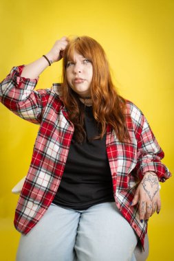 Kafasını kaşıyan bir kadın, düşünceli görünüyor ve bilgi işliyor.