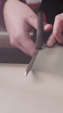 Bir makasla kağıt kesen bir adam.