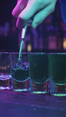 Bir sıra bardağa içki dolduran biri.