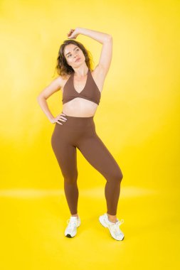 Genç bir kadın spor kıyafetleri içinde, spor ve sağlıklı yaşam tarzını temsil ediyor.