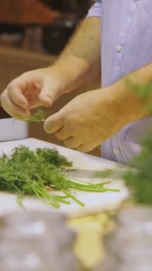 Mutfaktaki şef dereotu keser. Restoranda yemek pişirir, kapatır.