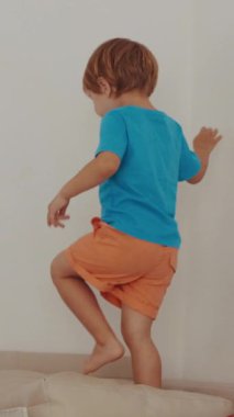 Yatağın üstünde duran küçük bir çocuk.