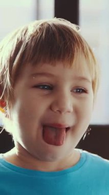 Küçük bir çocuk diliyle komik bir surat yapıyor.