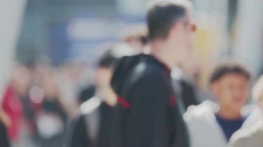 Anonim, bulanık kalabalık kalabalık kalabalık kalabalık kalabalık güneşli bir günde işlek bir şehir caddesinde yürüyor.