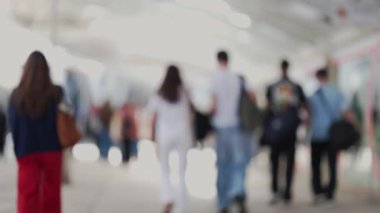 Genel bir şehir bağlamında yürüyen kalabalığın odaklanmış görüntüsü soyut bir arkaplan oluşturuyor.