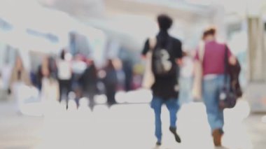 Şehir caddesinde ağır çekimde yürüyen kalabalığın bulanık arka planı