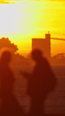 Gün batımının önünde duran bir grup insan.