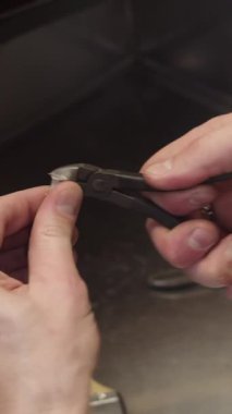 Bir adam bir pense tutuyor ve küçük bir nesneye bakıyor. Adamın aletleriyle objeyi incelediği gibi merak ve odaklanma kavramı