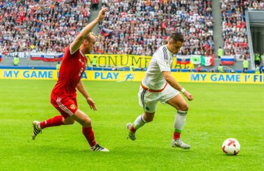 Kazan, Rusya - 24 Haziran 2017. Rusya milli futbol takımı orta saha oyuncusu Denis Glushakov, FIFA Konfederasyon Kupası maçında Meksika-Rusya maçında Meksikalı futbolcu Javier Hernandez 'e karşı..