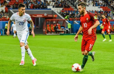 Kazan, Russia - June 28, 2017. Portugal midfielder Bernardo Silva against Chile player Charles Aranguiz during FIFA Confederations Cup 2017 semi-final Portugal vs Chile. clipart