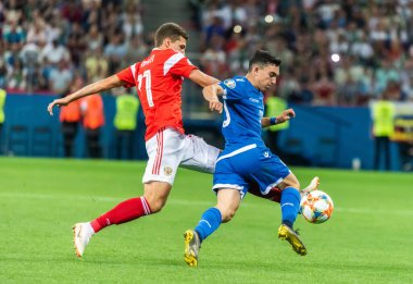 Nizhny Novgorod, Rusya - 11 Haziran 2019. Rusya milli takımı orta saha oyuncusu Roman Zobnin, UEFA Euro 2020 ön eleme karşılaşmasında Kıbrıs Rum savunma oyuncusu Ioannis Kosti 'ye karşı Nizhny Novgorod' da oynanan Rusya-Kıbrıs Rum Kesimi (1-0) karşılaşmasında mücadele etti..