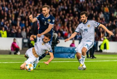 Glasgow, İskoçya, İngiltere - 6 Eylül 2019. Rusya futbolcuları Magomed Özdoyev ve Georgi Dzhikiya ve İskoçyalı futbolcu Stephen O 'Donnell UEFA Euro 2020 ön eleme karşılaşmasında Glasgow' da Rusya 'ya karşı İskoçya.