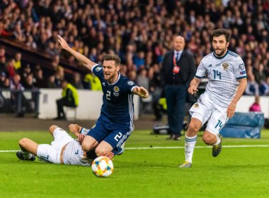 Glasgow, İskoçya, İngiltere - 6 Eylül 2019. Rusya futbolcuları Magomed Özdoyev ve Georgi Dzhikiya ve İskoçyalı futbolcu Stephen O 'Donnell UEFA Euro 2020 ön eleme karşılaşmasında Glasgow' da Rusya 'ya karşı İskoçya.
