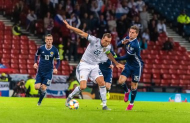 Glasgow, İskoçya, İngiltere - 6 Eylül 2019. Rusya Millî Futbol Takımı forveti Artem Dzyuba, UEFA Euro 2020 ön eleme karşılaşmasında İskoçya ile Rusya arasındaki Glasgow maçında İskoçya oyuncuları Callum McGregor ve Kenny McLean 'e karşı..