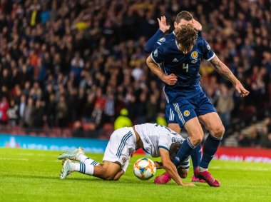 Glasgow, İskoçya, İngiltere - 6 Eylül 2019. İskoçya Millî Futbol Takımı oyuncusu Charlie Mulgrew, UEFA Euro 2020 ön eleme karşılaşmasında Rusya 'nın orta saha oyuncusu Ilzat Akhmetov' a faul yaptı..